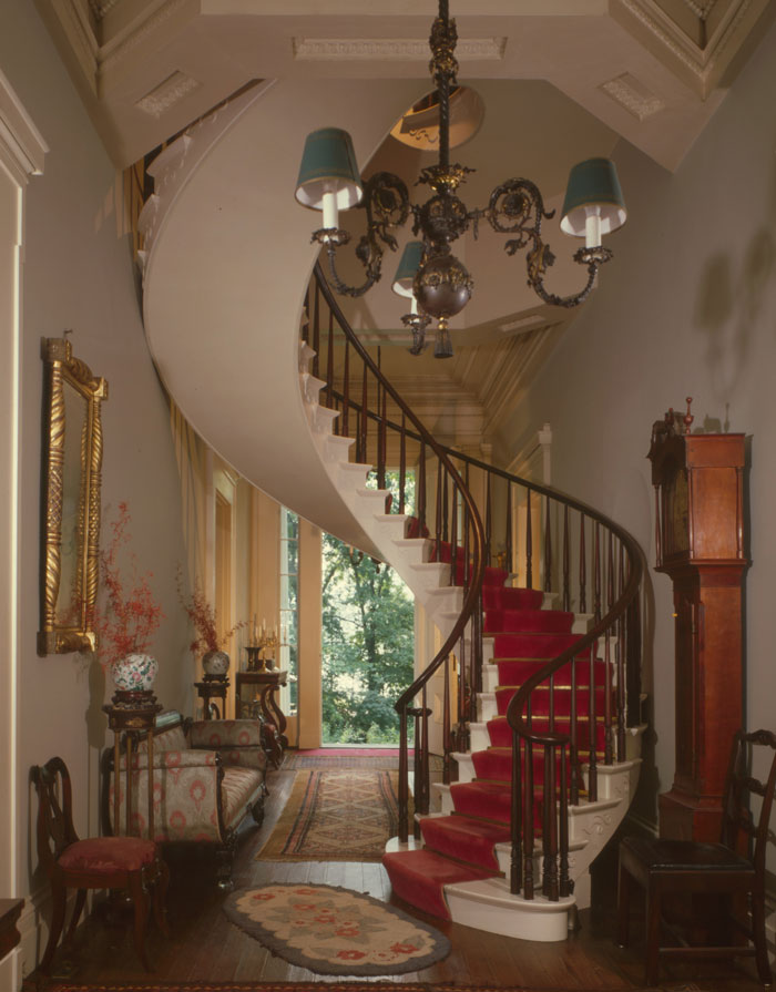 vintage spiral stairs with red carpet on it in a Captain Charles L. Shrewsbury House in USA