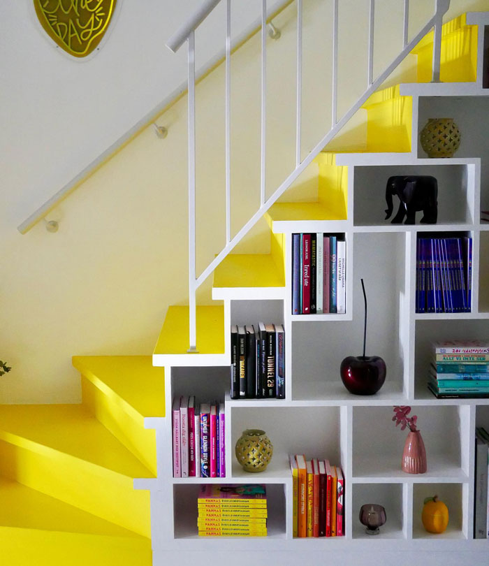 yellow and white staircase with bookshelves on the walls