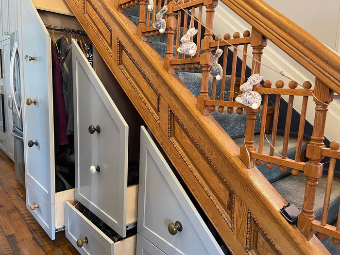 stairs with drawers on it and wooden railings