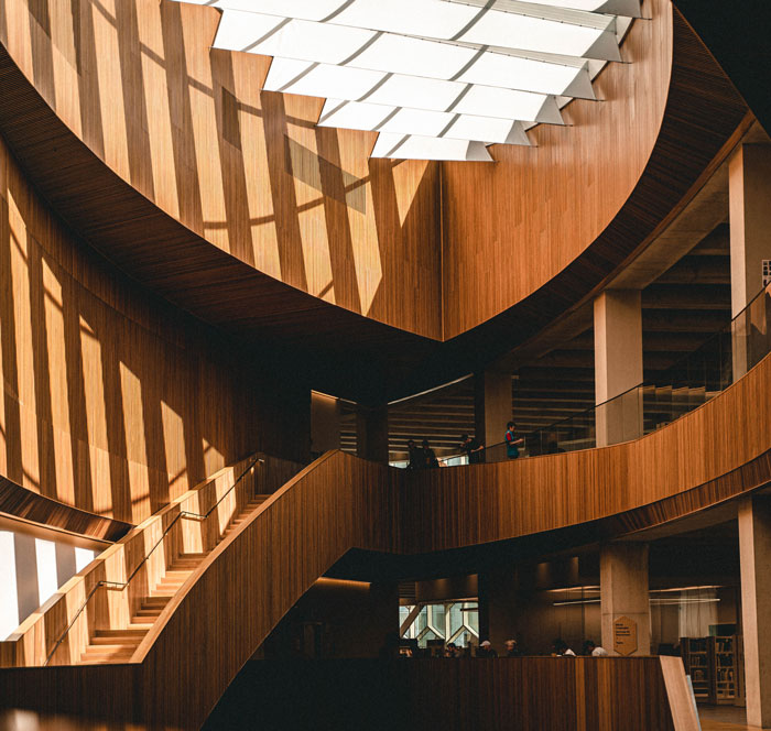 a spiral wooden staircase in a building with a skylight