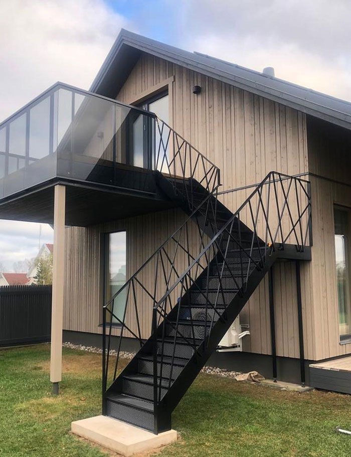 black metal stairs beside wooden house
