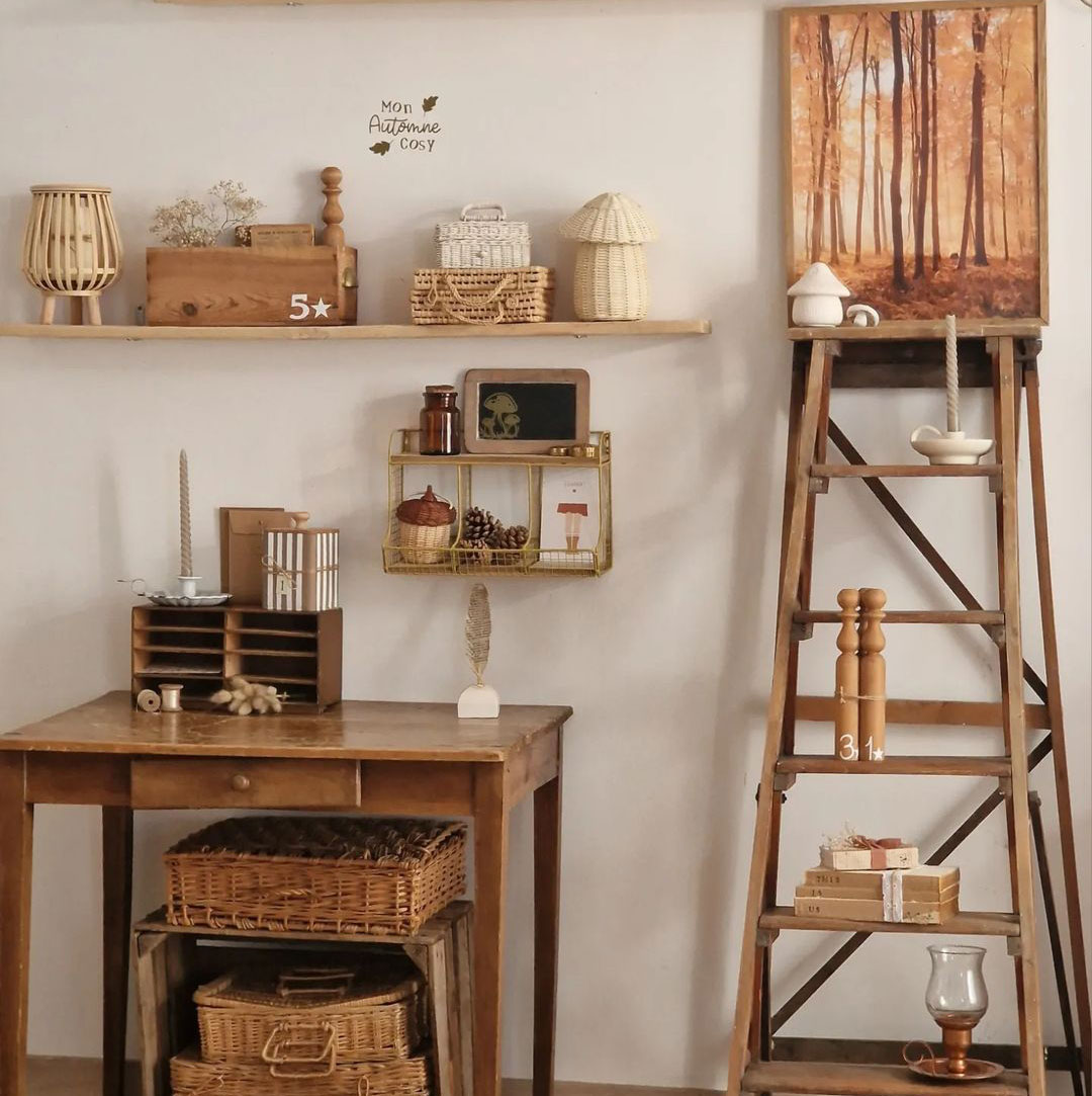 Taupe-themed cozy room with wooden furniture, rustic decor items, and fall art on a ladder shelf.