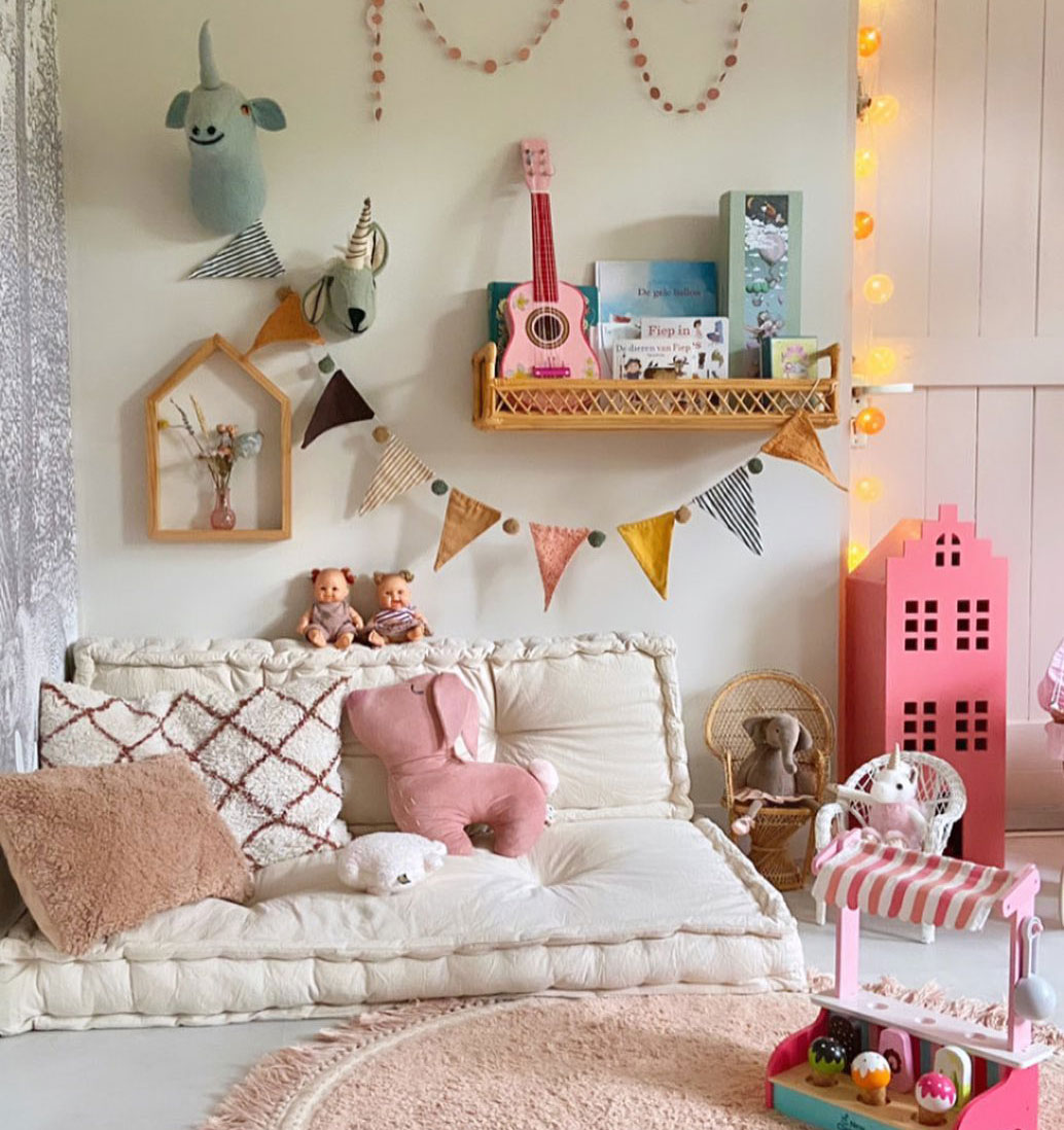 Cozy children's room with taupe cushions, pink plush toys, and colorful wall decor, creating a playful and inviting space.
