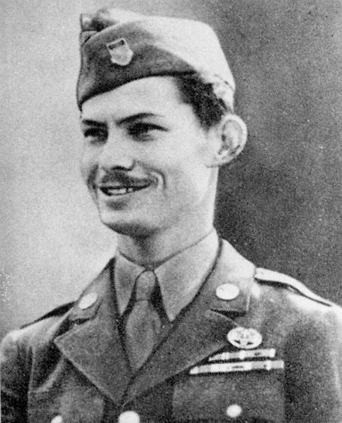 Black and white photo of a smiling WWII soldier in uniform, representing one of the coolest people ever lived.