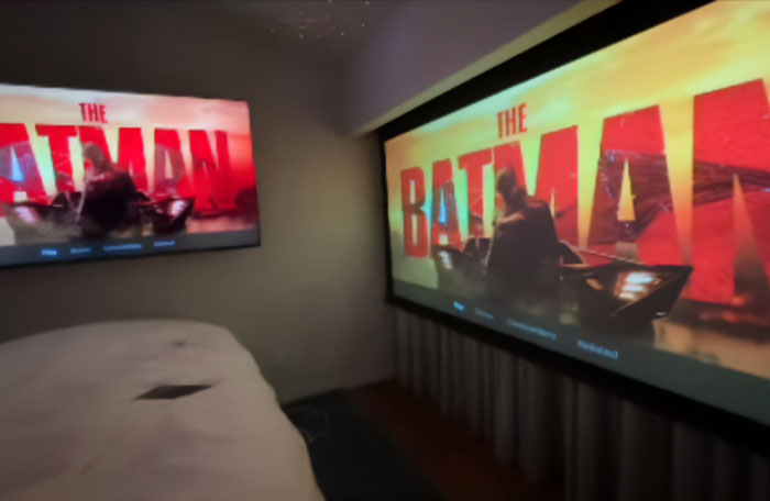 Home theater with Batman movie screens, referencing mysterious online posts.