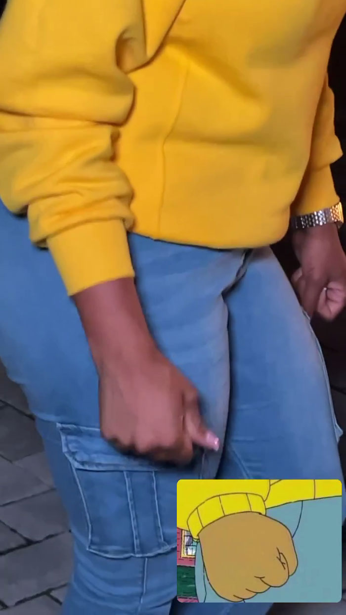 Woman in yellow and jeans recreating an iconic meme at a meme-themed party.