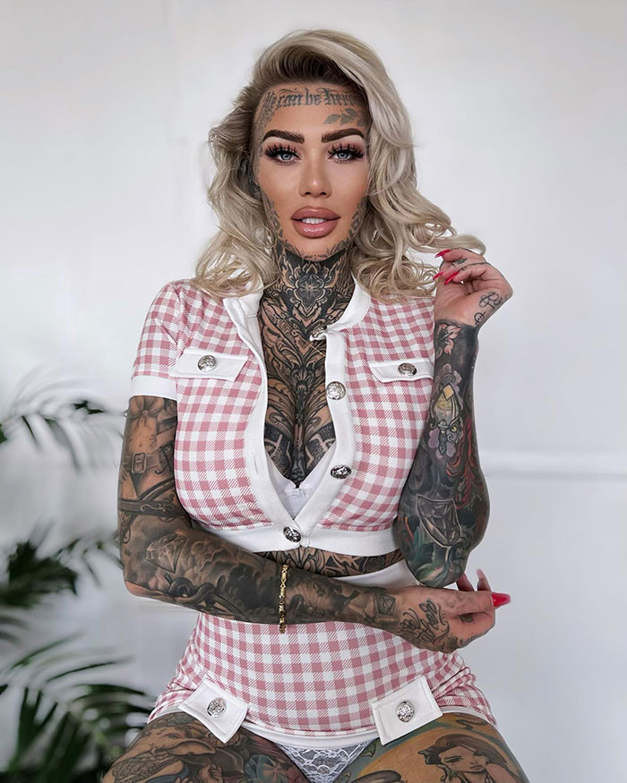 "Britain’s most tattooed woman in a pink checkered outfit, showcasing extensive body tattoos. "Britain’s most tattooed woman in a pink checkered outfit, showcasing extensive body tattoos.