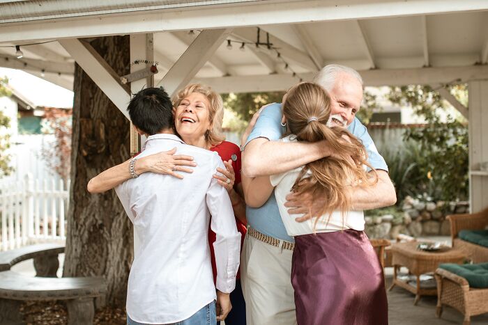 Two mothers hugging their adult children warmly outdoors, capturing unspoken mom code moments and family connection.