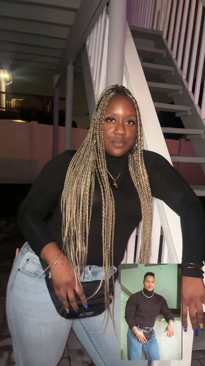 Woman at meme-themed party dressed as "The Rock", recreating iconic photo against staircase.