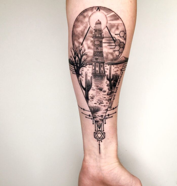 Memorial tattoo featuring a lighthouse and desert landscape on forearm.