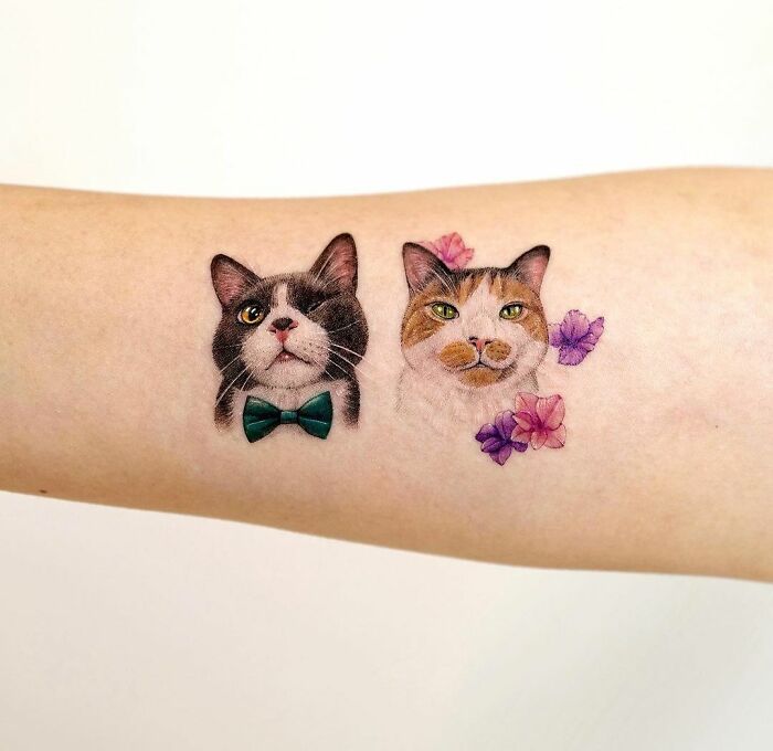 Cat tattoos on arm, with floral accents and a bow tie, as a memorial design idea to honor family.