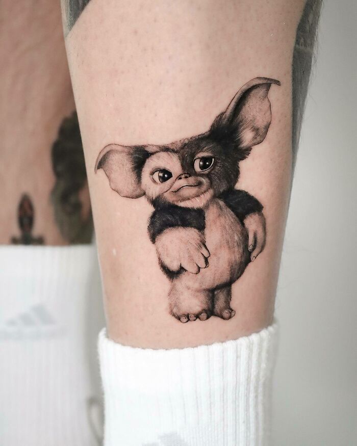 '90s culture tattoo featuring a Gremlin character on a person's leg.