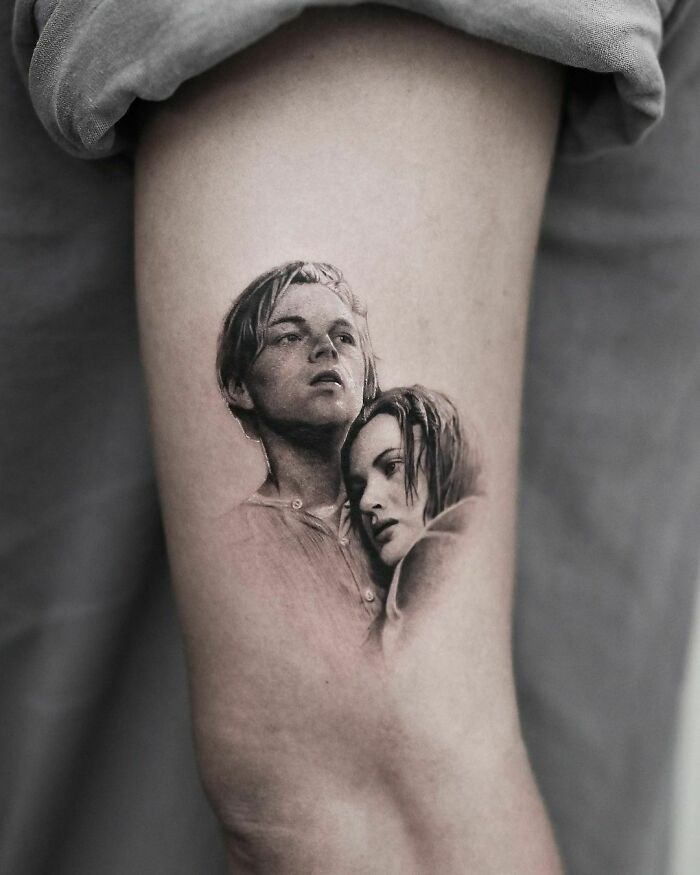 '90s tattoo featuring a detailed portrait of a man and woman on an arm.