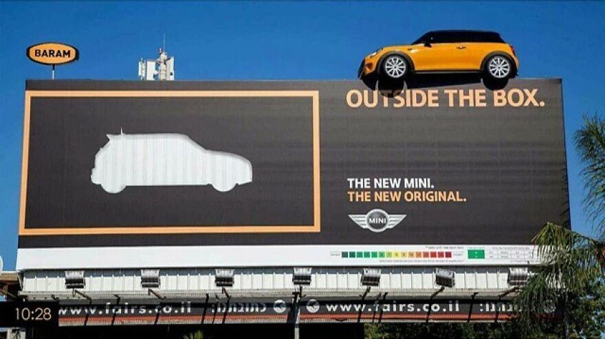 Clever Mini car advertisement using a billboard with a car parked outside the box shape, illustrating smart advertising.