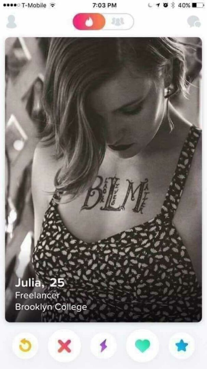 Woman with "BLM" tattoo on chest, displayed on a dating profile.
