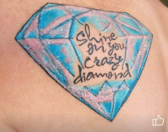 Tattoo of blue and pink diamond with "Shine on you crazy diamond" text, showcasing worst tattoo examples.