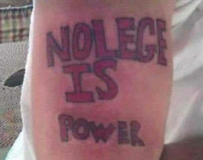 Misspelled tattoo reading "Nolege is Powr" in bold letters on skin.