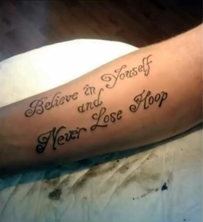 Tattoo with error: "Believe in Youself and Never Lose Hoop" on forearm.