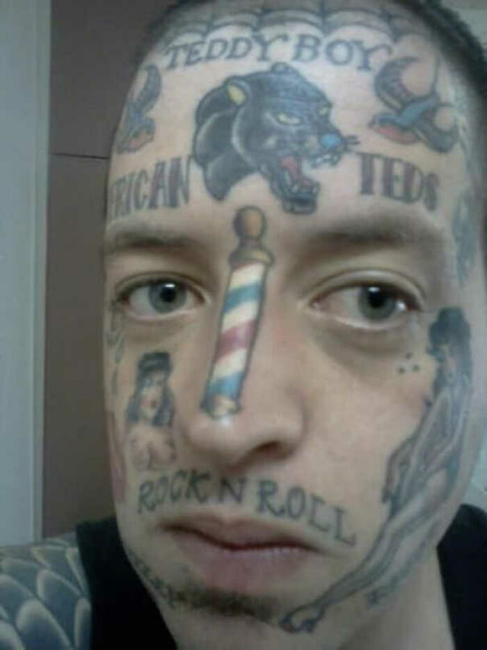 Face with numerous tattoos, including "Teddy Boy" and a panther, showcasing bad tattoo decisions.