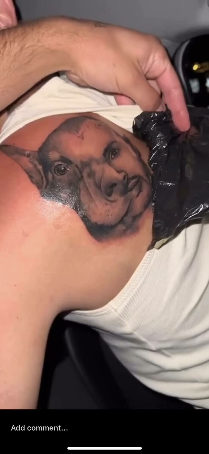 "Unusual tattoo of a pig and human face hybrid on a person's shoulder."