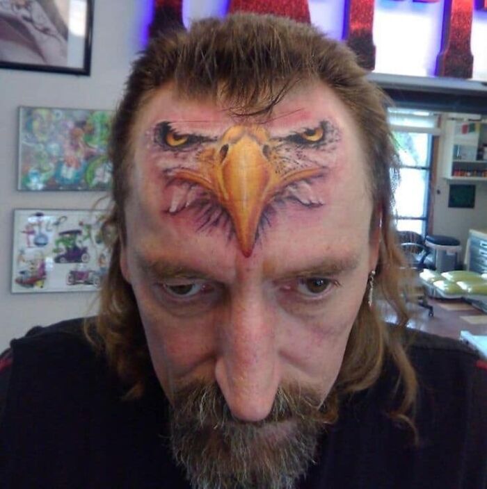 Man with an eagle tattoo on his forehead, representing a bold and unusual tattoo choice.