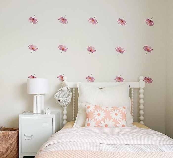 Bedroom decorated with removable floral wall decals above a white bed, showcasing cool and inspiring bedroom wall decor ideas.