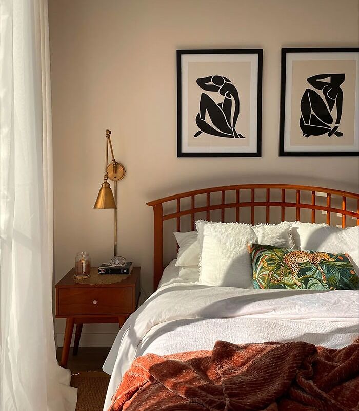 Matching set of modern black and white wall art hanging above a cozy bedroom bed for cool bedroom wall decor ideas.