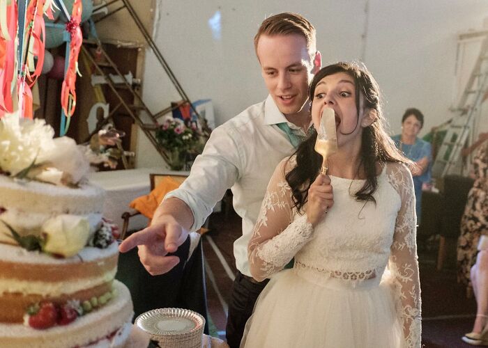 A Photograph Of Newly Weds Cutting Cake