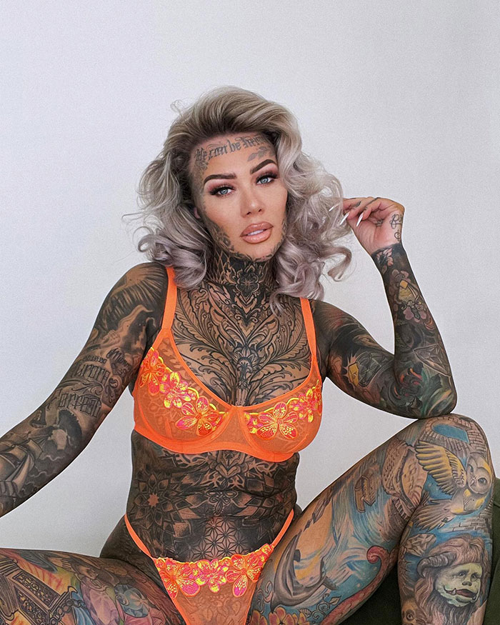 Britain's most tattooed woman in vibrant orange lingerie, showcasing extensive body tattoos. Britain's most tattooed woman in vibrant orange lingerie, showcasing extensive body tattoos.