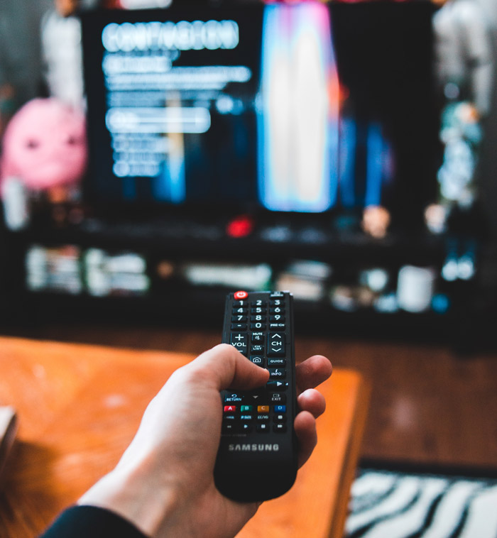 Person holding black remote control