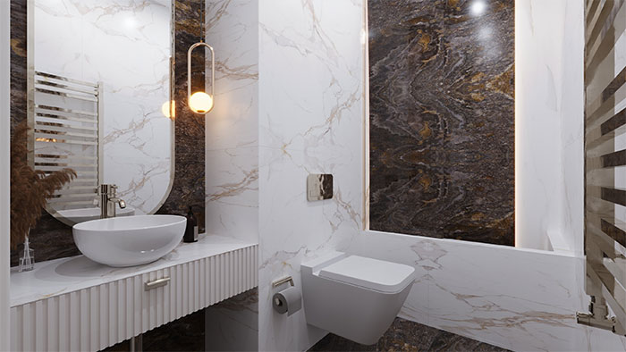 Modern bathroom featuring marble walls with elegant tile design, a white sink, toilet, and a built-in tub for stylish flooring.