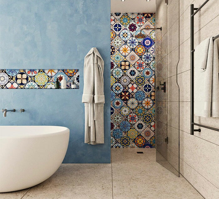 Bathroom with beautiful puzzle tile design on shower wall and accent strip against blue and beige walls.
