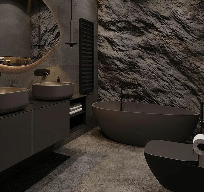 Modern black bathroom with textured stone tile walls and matching black sinks, bathtub, and flooring design ideas.