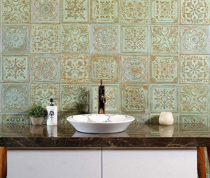 Bathroom with green Morocco tile design on walls and a modern white sink with dark marble countertop.
