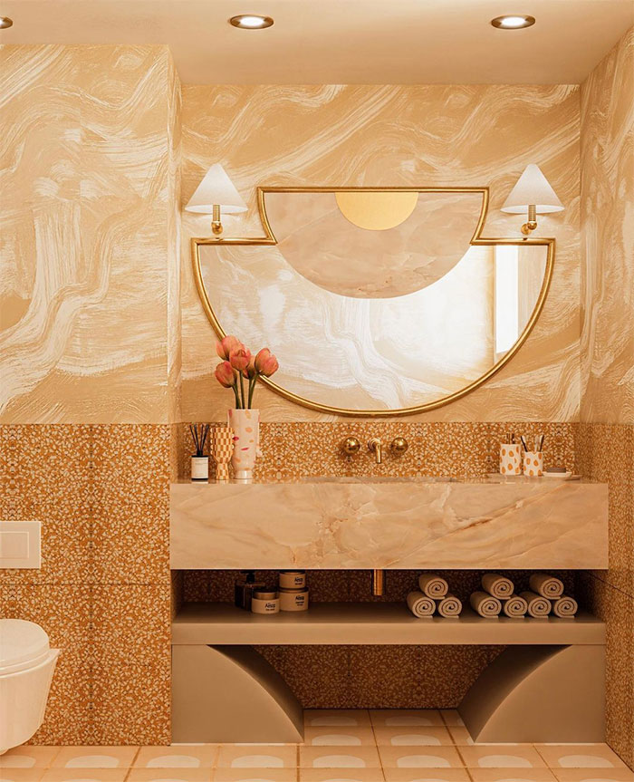 Yellow bathroom with mosaic tile design on walls and flooring, featuring a decorative mirror and marble sink countertop.