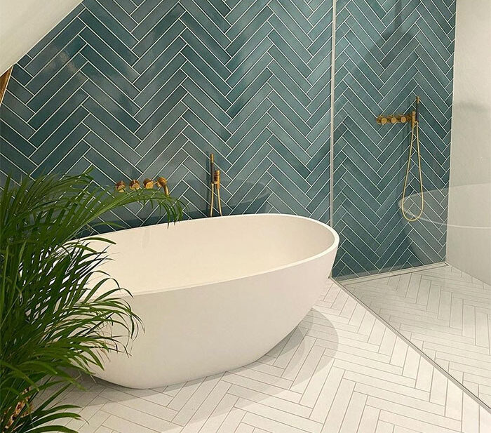 Bathroom with green and white herringbone tiles on walls and flooring showcasing beautiful bathroom tile design ideas.