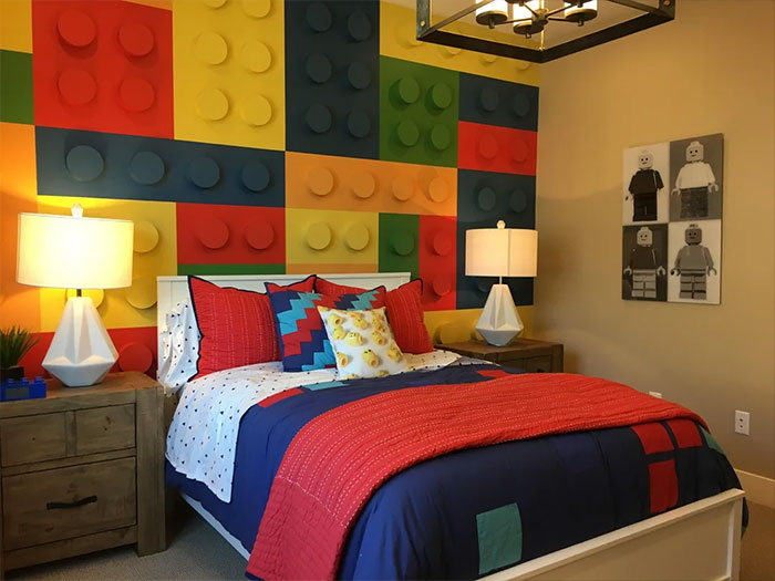 Bedroom wall decor inspired by Lego blocks with colorful 3D paneling and matching bedding in a vibrant design.