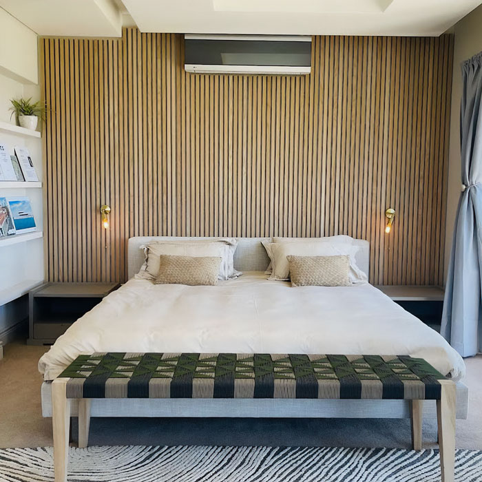 Modern bedroom featuring cool bedroom wall decor ideas with vertical wooden slats and minimalist lighting.