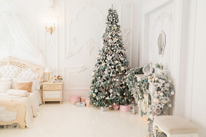 Christmas tree with affordable decorations in a white bedroom, showcasing budget-friendly Christmas decor ideas for 2024.