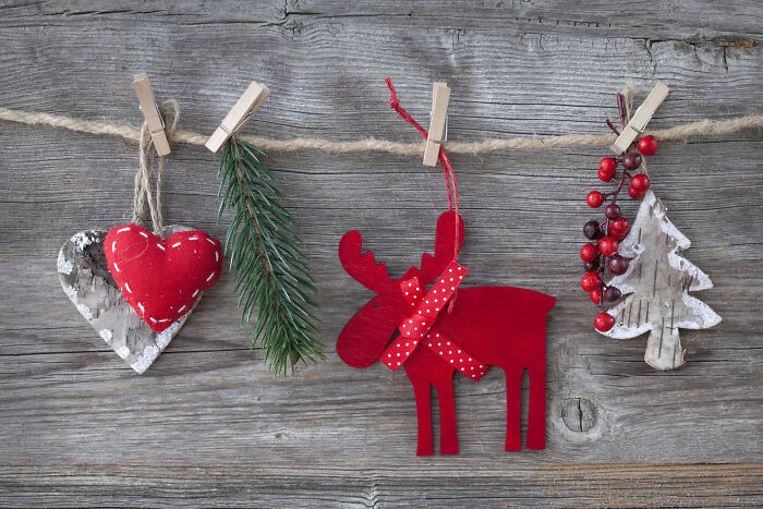 Wooden Christmas tree decor and rustic holiday ornaments hanging on twine, showcasing affordable Christmas decor ideas.