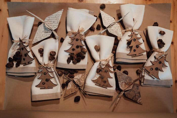 Napkins decorated with affordable Christmas decor elements including wooden trees and pine cones on a brown background.