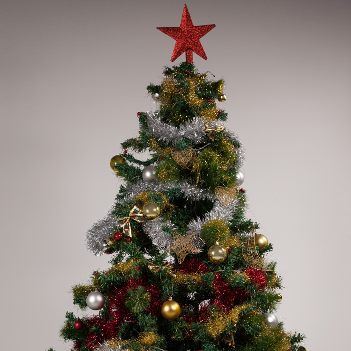Christmas tree decorated with colorful tinsel and ornaments, topped with red star and gifts placed underneath.