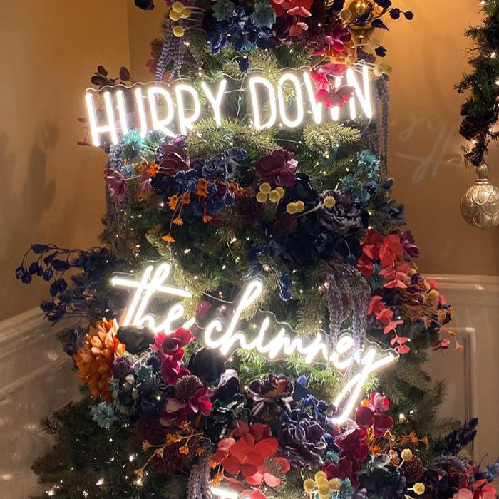 Christmas tree decorated with colorful flowers and bright neon signs for magical Christmas tree decorations.