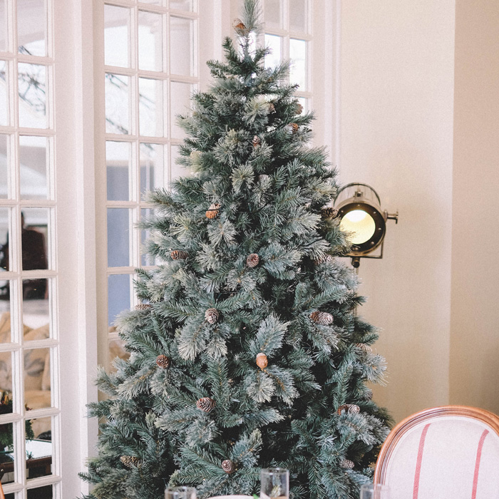 Christmas tree decorated with pine cones and frosted branches, showcasing magical Christmas tree decorations ideas.