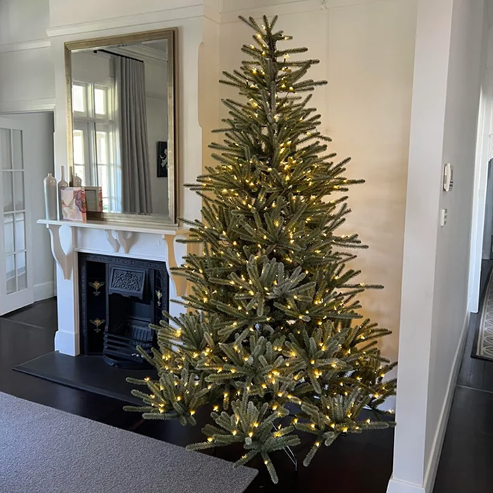 Spruce Christmas tree decorated with string lights near the fireplace, showcasing magical Christmas tree decorations ideas.