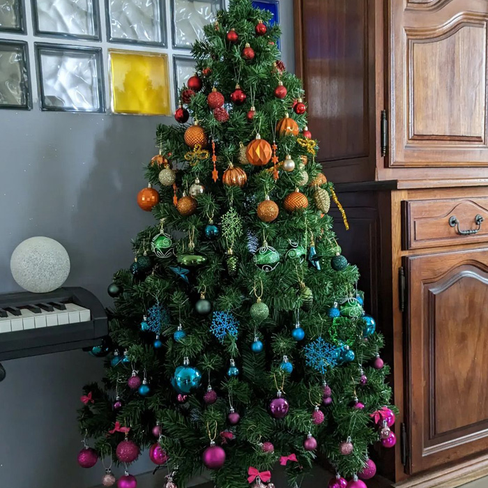Christmas tree decorated with rainbow-colored baubles and ornaments showcasing magical Christmas tree decorations ideas.