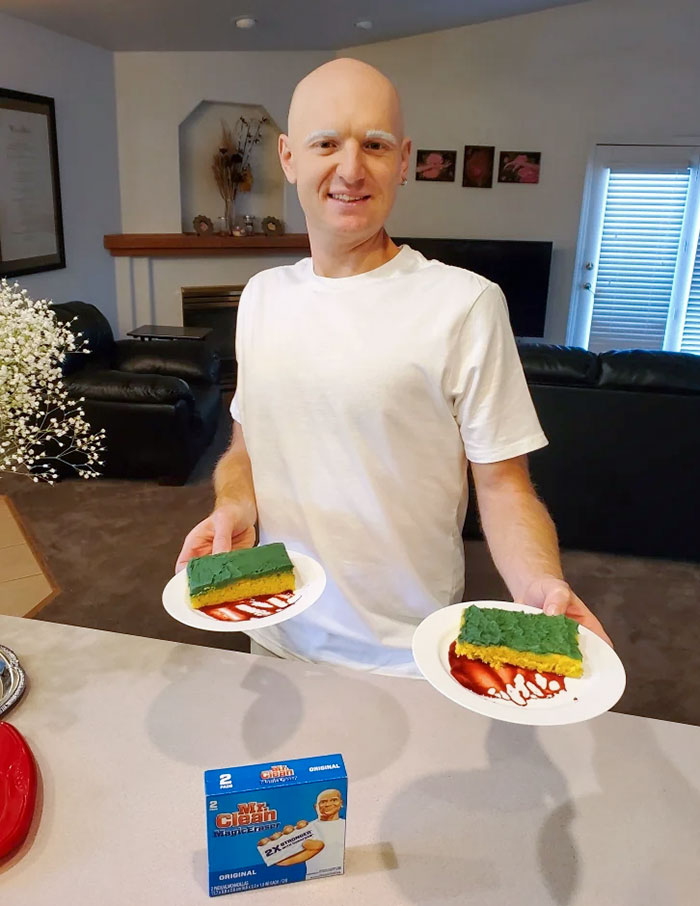 Man dressed in a clever Halloween costume inspired by Mr. Clean holding two plates with themed cake slices.