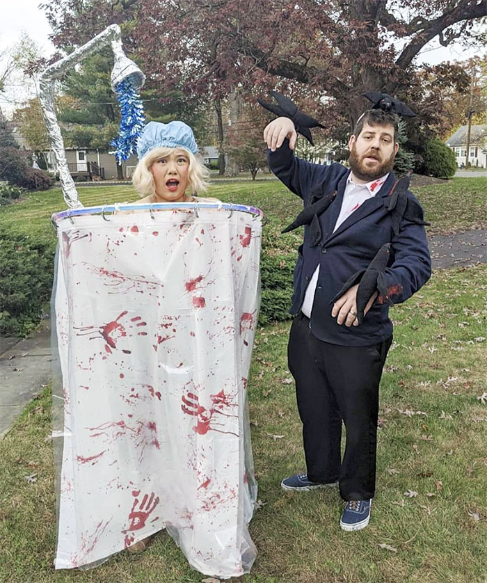 Two people in clever Halloween costumes, one dressed as a bloody shower scene, the other as a man with black crows.