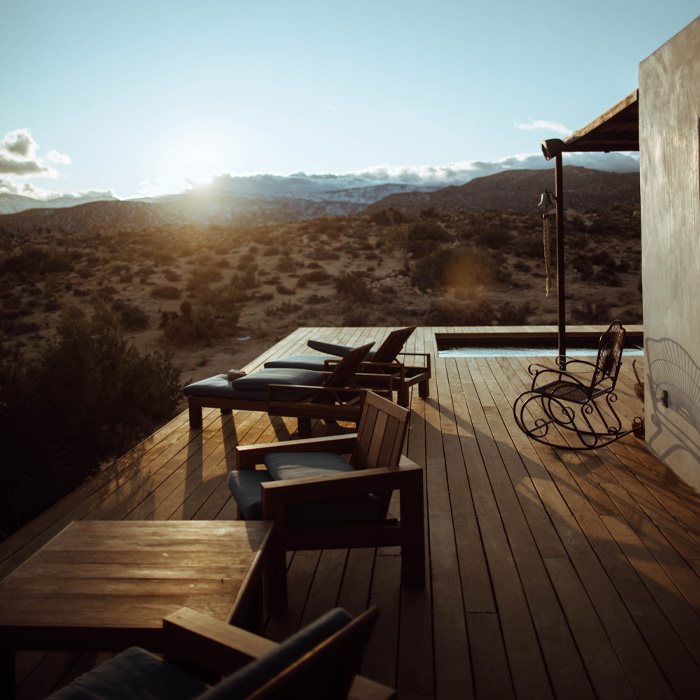 Brown wooden chairs on a backyard deck at sunset, showcasing creative backyard deck ideas for relaxing outdoors.