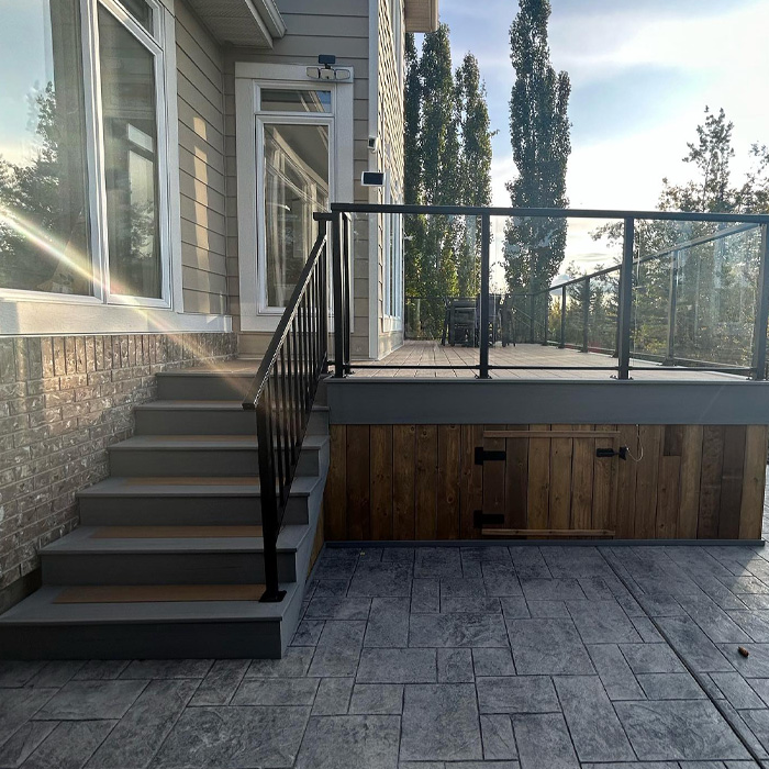 Modern backyard deck with black railings and wooden accents, showcasing creative backyard deck ideas for outdoor enjoyment.